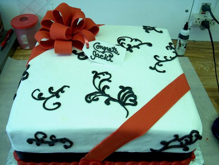Very unique sheet cake decorated with red ribbon