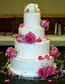 White wedding cake decorated with fresh pink roses 